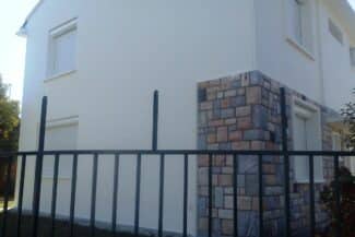 Mur blanc avec parement en pierre et garde-corps métallique