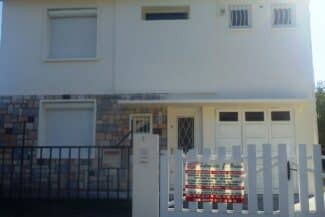 Maison avec porte de garage blanche et façade bicolore