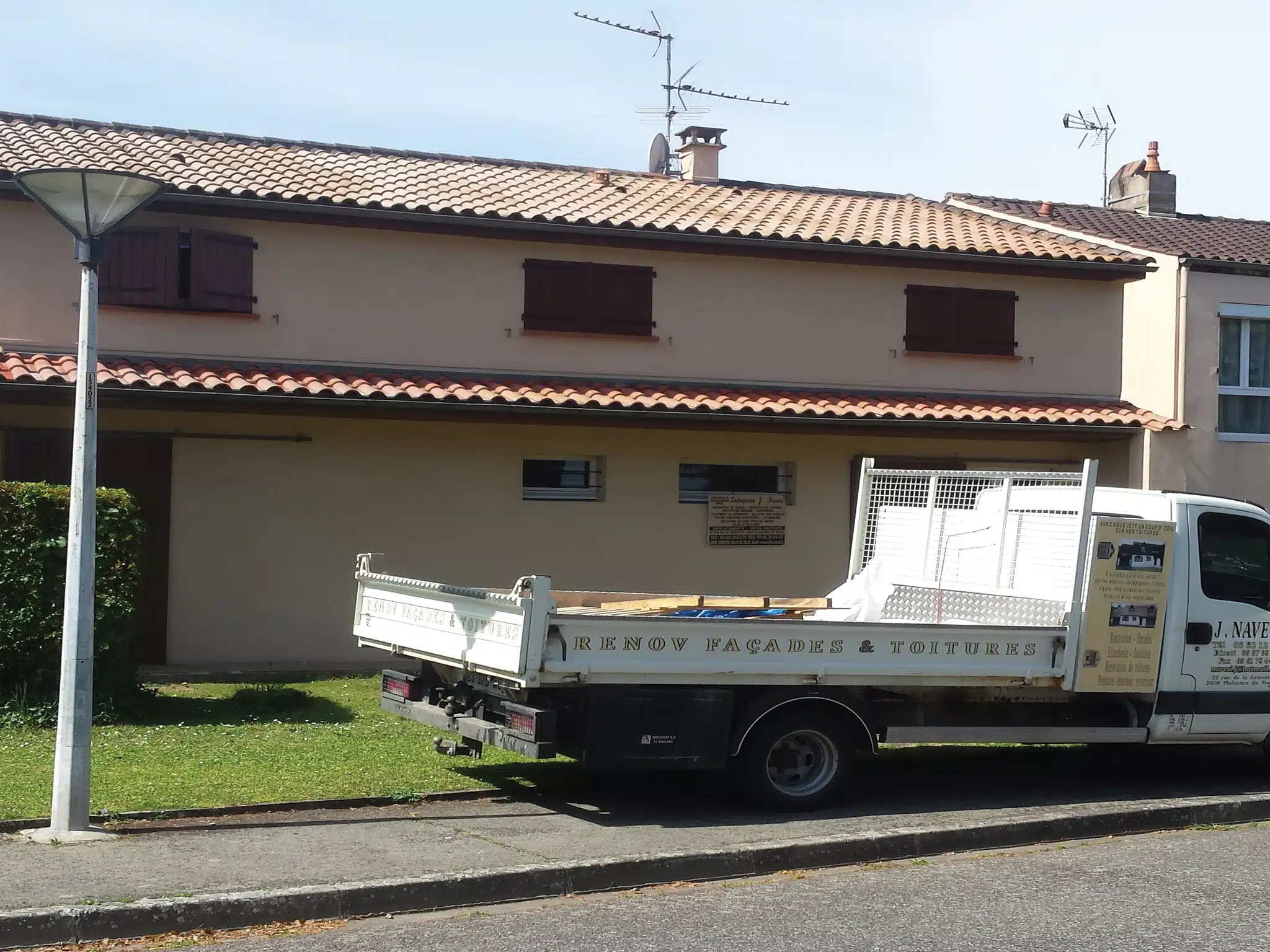 Camion nacelle devant une maison en travaux