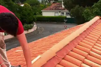 Couvreur posant le faîtage sur une toiture neuve