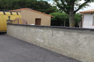 Mur de clôture et façade rénovés le long d'une allée