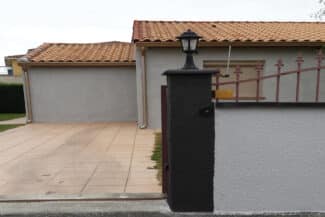 Entrée de propriété avec piliers noirs devant le garage