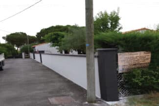 Allée bordée d'un mur de clôture rénové et de piliers