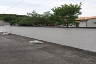 Long mur de clôture enduit bordant une propriété
