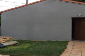Mur en crépi gris clair avec porte de service