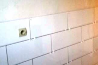 Faïence et prise électrique posées sur un mur de salle de bains