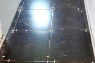 Carrelage de sol sombre posé dans une salle de bains