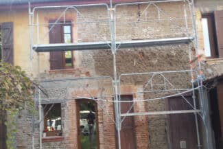 Échafaudage devant une maison ancienne en briques avant ravalement