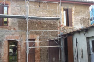 Maison ancienne en briques sous échafaudage vue de côté