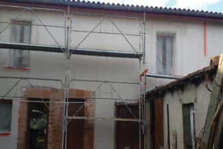 Façade décrépie entourée d'un échafaudage pendant les travaux
