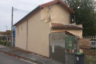 Maison ancienne en enduit clair coiffée de tuiles canal