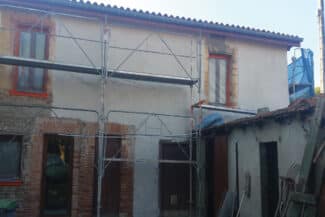Échafaudage devant une maison en briques avant pose de l'enduit