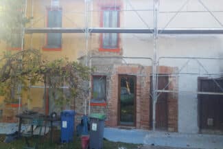 Échafaudage monté devant une maison ancienne à façade jaune