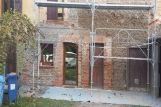 Façade en briques nues pendant la réfection de l'enduit