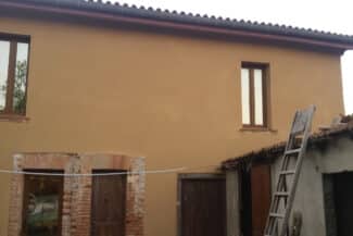 Façade ocre en cours de rénovation avec échelle