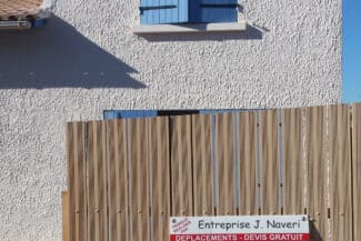 Palissade en bois devant un mur enduit clair