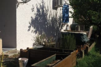 Mur blanc rénové avec matériel de chantier au pied