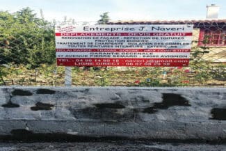 Panneau de chantier devant un mur de clôture en construction