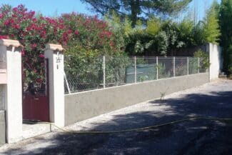 Mur de clôture rénové le long d'une allée