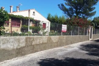 Muret de clôture enduit bordant une propriété