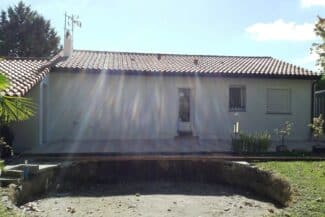 Maison basse à toiture en tuiles vue depuis la rue
