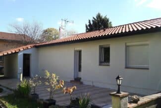 Maison de plain-pied en enduit clair avec toiture en tuiles