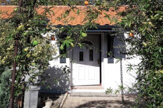 Entrée de maison rénovée entourée de végétation