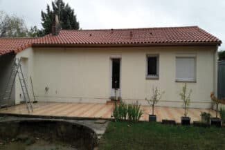Maison beige avec terrasse et échelle appuyée à la façade