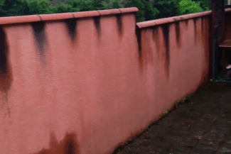 Mur rouge marqué de coulures avant nettoyage
