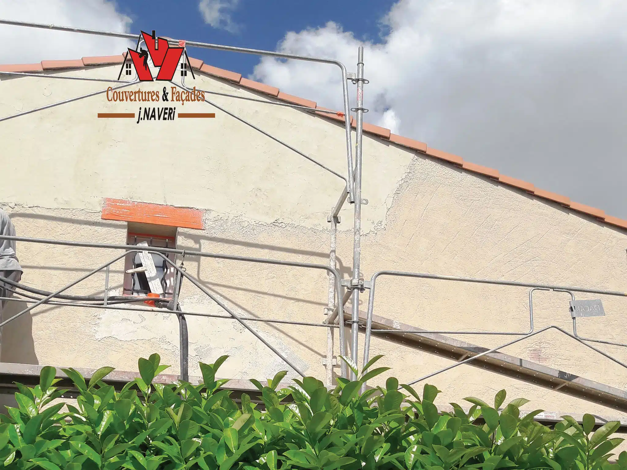 Façade en travaux avec câbles et tuiles stockées