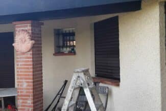 Façade en cours de travaux avec échelle et pilier en brique
