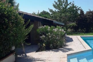 Maison avec planche de rive vue depuis le jardin et la piscine