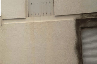 Bas de façade en enduit beige sali avant ravalement