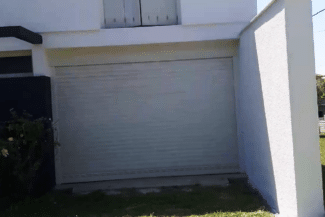 Façade blanche rénovée avec porte de garage sectionnelle