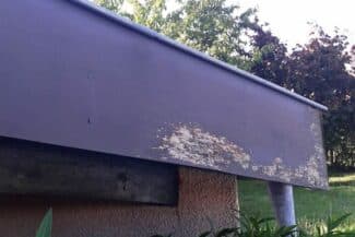Planche de rive abîmée sous un débord de toit