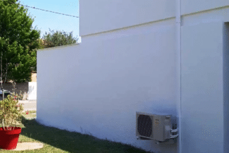 Mur de maison repeint en blanc vu depuis la cour