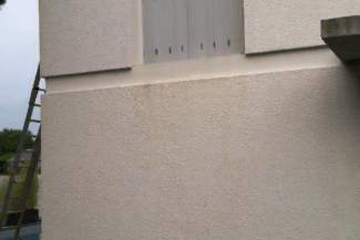 Mur blanc fraîchement enduit avec échelle appuyée