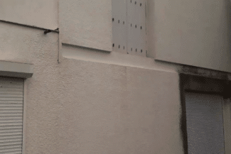 Angle de façade blanche avec volets roulants après ravalement