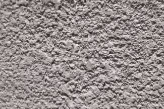 Gros plan sur un enduit de façade à grain écrasé