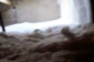 Isolant soufflé réparti sur le plancher des combles perdus