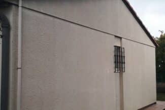 Mur de façade traité autour d'une fenêtre grillagée