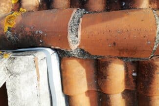 Tuiles fissurées réparées près d'une fenêtre de toit