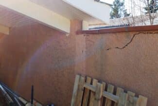 Fissure traversant un mur enduit rosé à Fonsorbes