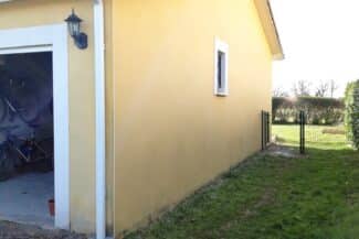 Façade jaune propre bordée d'un grillage à Cugnaux