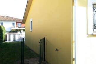 Mur jaune pâle nettoyé le long d'une clôture à Cugnaux