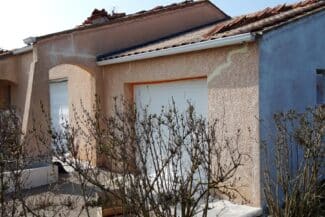 Mur clair avec fissure colmatée près de la porte de garage