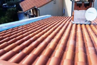 Toiture en tuiles et bâche de protection bleue à Frouzins