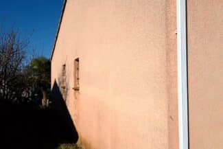 Mur enduit rosé fraîchement appliqué sur une façade