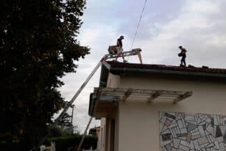 Deux couvreurs déposant l'ancienne couverture depuis un échafaudage à Plaisance-du-Touch