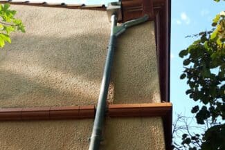 Gouttière et descente pluviale le long d'un mur